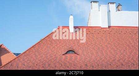 Rotes Ziegeldach gegen den blauen Himmel Stockfoto