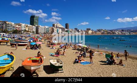 Gran Canaria, Las Palmas, Playa de las Canteras, tagsüber Blick über den Strand auf Meereshöhe, voller Menschen, türkisfarbenes Wasser, blauer Himmel mit Schafswolken, Boote am Strand, Boote im Wasser Stockfoto