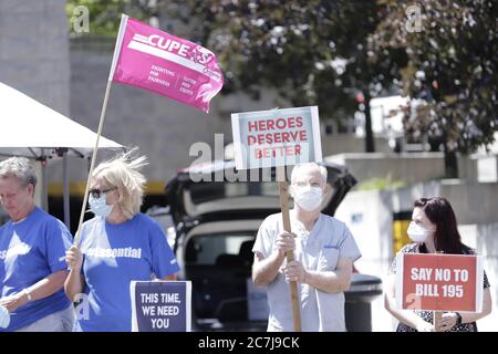 Gesundheitshelfer werden gesehen, wie sie Plakate halten und gegen das Gesetz 195 der Regierung von Ontario protestieren Stockfoto