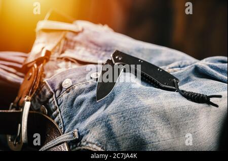 Taschenmesser mit alten Jeans im Hintergrund ist Taschenmesser eines der täglichen Carry (EDC) Artikel für Männer. Stockfoto