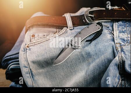 Taschenmesser mit alten Jeans im Hintergrund ist Taschenmesser eines der täglichen Carry (EDC) Artikel für Männer. Stockfoto