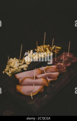 Vertikale Aufnahme von Baloney und Käse in Scheiben geschnitten auf einem Holz Fach Stockfoto