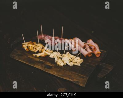 High-Angle-Schuss von Käse und Baloney's auf einem Holztablett Stockfoto