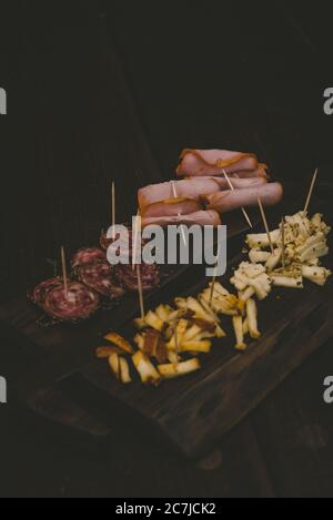 Vertikale Aufnahme von Baloney und Käse in Scheiben geschnitten auf einem Holz Platine Stockfoto