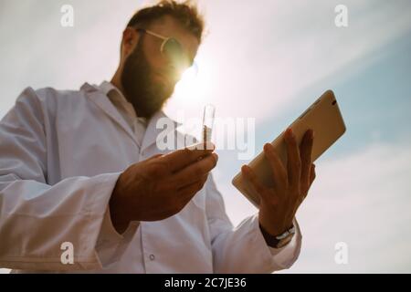 Männliche kaukasischen Technologen Agronom mit Tablet-Computer im Bereich der Weizen Kontrolle Qualität und Wachstum von Kulturen für die Landwirtschaft. Stockfoto