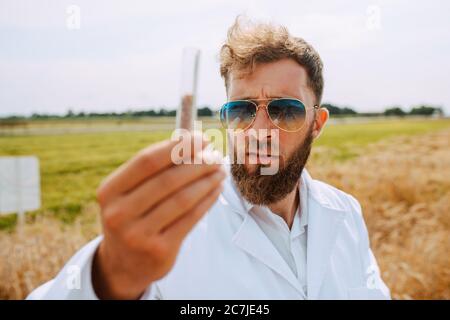 Männliche kaukasischen Technologen Agronom mit Tablet-Computer im Bereich der Weizen Kontrolle Qualität und Wachstum von Kulturen für die Landwirtschaft. Stockfoto