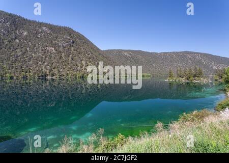 Bergige Landschaft, die sich im Thompson Fluss unter dem klaren widerspiegelt Himmel Stockfoto