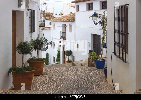 Gasse mit Treppen und Blumentöpfen entlang der weiß getünchten Häuser in der Altstadt von Altea, Costa Blanca, Spanien Stockfoto