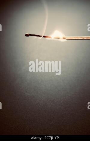 Vertikale Nahaufnahme von einem Streichholzstock, der wunderschön in einem brennt Dunkles Zimmer Stockfoto