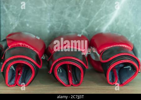 Boxhandschuhe, die auf Holzregal in der Turnhalle platziert werden. Stockfoto