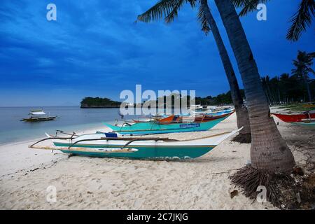 Outrigger Traditionelles Fischerboot, das am Strand an der Ostküste der Malapascua Insel, Cebu, Central Visayas, Philippinen, festgemacht ist Stockfoto