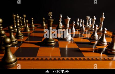 Schachfiguren auf Schachbrett mit dunklem Hintergrund Stockfoto