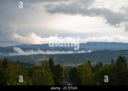Schöne Landschaft einer Landschaft mit viel hoch Berge und Tannenbäume unter einem wolkigen Himmel Stockfoto