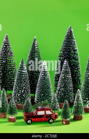 Weihnachtsbaumschmuck, Auto rot mit Tannenbaum, grüner Hintergrund, Symbolbild, Weihnachtszeit, Stockfoto