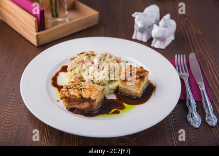 Schweinefleisch Medaillons mit Kartoffelpüree und Salat auf einem weißen Teller serviert, Restaurant-Menü Stockfoto
