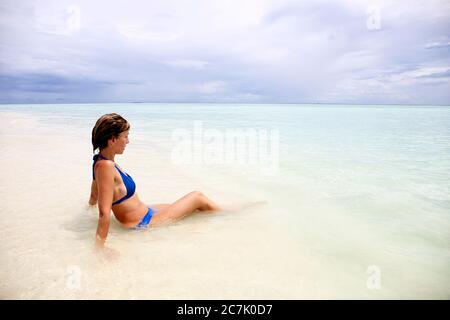 Malediven, Porträt von attraktiven jungen Frau Entspannung am Strand Stockfoto