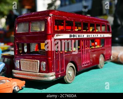 Selektive Fokusaufnahme einer niedlichen roten Busfigur auf Eine blaue Oberfläche Stockfoto