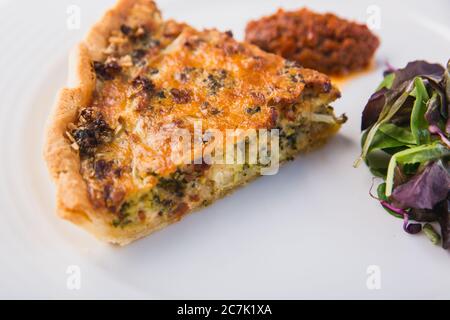 Schneiden Sie köstliche frische Gemüsekuchen auf weißem Teller Stockfoto