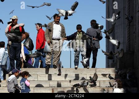 Ein Treffen von Menschen und Tauben am Eingang der 400 Jahre alten Yeni Camii (Neue Moschee) in Eminonu in Istanbul in der Türkei. Stockfoto