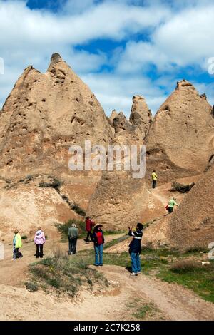 Touristen blicken auf die herrliche märchenhafte Schornsteinlandschaft des Devrent-Tals in der türkischen Region Kappadokien. Stockfoto