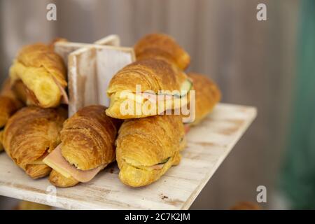 Nahaufnahme von Sandwiches auf einem Holztablett unter den Lichtern Mit unscharfem Hintergrund Stockfoto