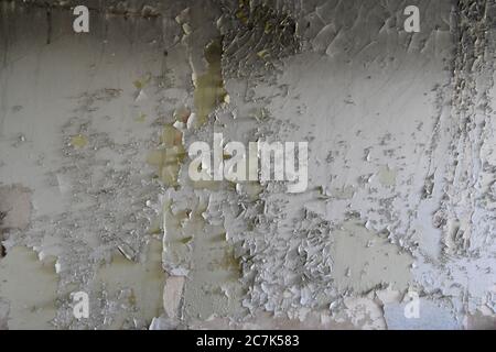 Gehackte alte weiße Farbe an der Wand. Stockfoto