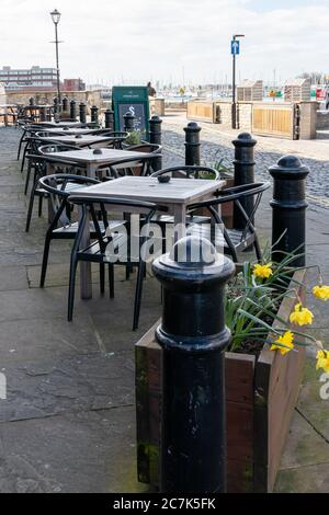 Leere Stühle und Tische vor einem Pub ohne Kunden Stockfoto