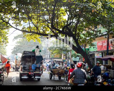 Mandalay, Myanmar - EIN Mann, der im Schatten eines großen Baumes auf einen LKW fährt, auf dem Zay Cho Markt, dem größten traditionellen Markt in Myanmar. Stockfoto