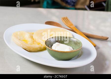 Käseknödel auf dem weißen Teller, in grüner Schüssel aufgesüßen. Traditionelle georgische Küche. Käse Khin. Stockfoto