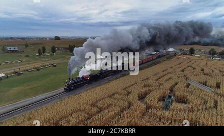 STRASBURG, USA - Oct 07, 2019: Luftaufnahme von Doppelkopfdampflokomotiven Puffing Black Smoke and Steam auf einem AUT durch die Landschaft Stockfoto