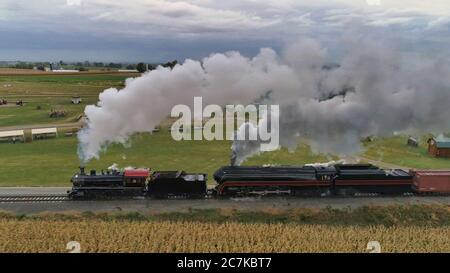 STRASBURG, USA - Oct 07, 2019: Luftaufnahme von Doppelkopfdampflokomotiven Puffing Black Smoke and Steam auf einem AUT durch die Landschaft Stockfoto