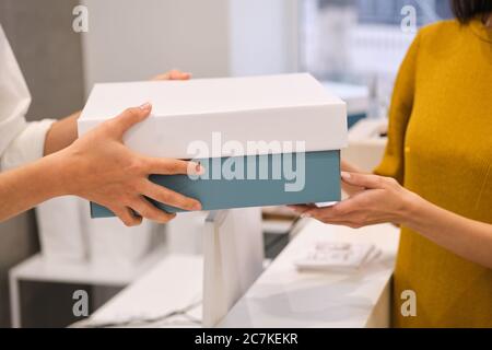 Close up Mode Berater geben Verpackung Kleidung an Kunden im Geschäft Stockfoto