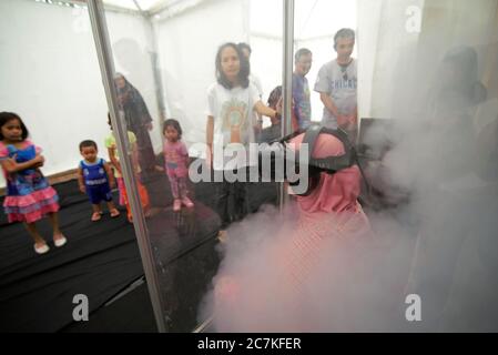 Ein Besucher, der sich während einer öffentlichen Veranstaltung von Greenpeace in Jakarta mit einer virtuellen Realität über die reiche Artenvielfalt des tropischen Regenwaldes ausschaut. Stockfoto