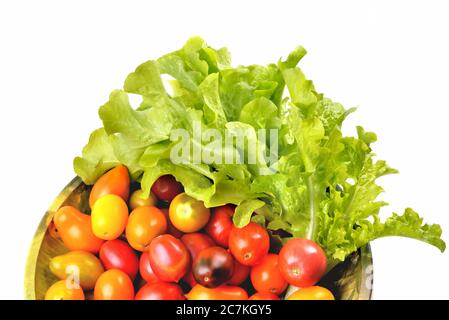 Salat gelbe und rote Tomaten, Kirschtomaten auf einem Vintage-Gericht weißen Hintergrund, isolieren, Draufsicht close-up Stockfoto