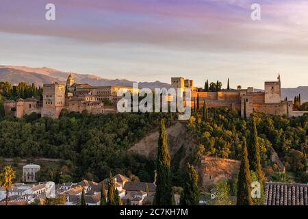 Oberhalb des Valle Del Darro erleuchtet die Abendsonne Granadas spektakuläre Alhambra mit der Sierra Nevada in der Ferne. Stockfoto