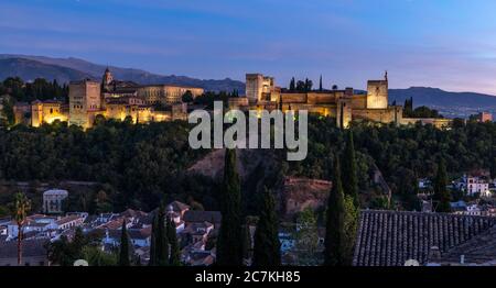 Oberhalb des Valle Del Darro erleuchtet die Abendsonne Granadas spektakuläre Alhambra mit der Sierra Nevada in der Ferne. Stockfoto