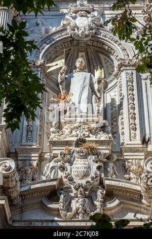 San Juan de Dios, der schutzpatron von Granada, steht auf einem verzierten Sockel an der Fassade der Iglesia de San Juan de Dios. Stockfoto