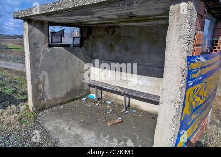 Betonbehelfsbehelfsmäßige und schmutzige Bushaltestelle in einer Siedlung in Serbien. Stockfoto