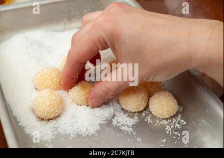 Frau Hand Herstellung Beijinho de Coco, eine traditionelle brasilianische Süßigkeiten namens Coconuts Little Kiss. Seitenansicht. Horizontale Aufnahme. Nahaufnahme. Stockfoto