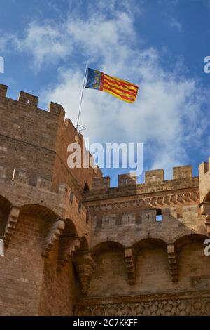 Nahaufnahme der Flagge der valencianischen Gemeinde und der Stadt Valencia, die im Wind auf dem atemberaubenden Torres de Serranos weht Stockfoto