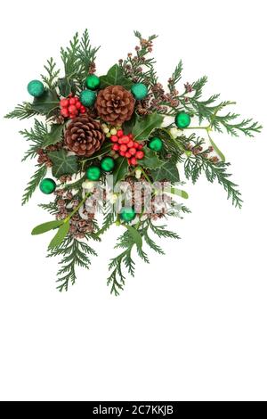 Weihnachtskomposition mit grünen Kugeln & Wintergrün mit Stechpalme, Mistel, Efeu, Tannenzapfen & Zederntanne auf weißem Hintergrund. Stockfoto