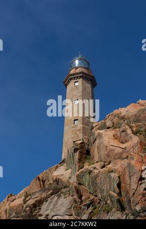 Vertikales Bild des Leuchtturms von Cabo Vilan in der Felsen unter dem Sonnenlicht in Spanien Stockfoto