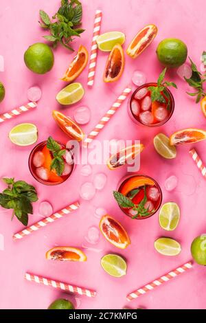 Sommermuster mit Zitrusscheiben und rotem Getränk Stockfoto