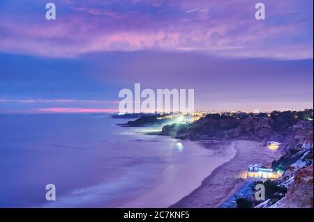 Europa, Portugal, Algarve, Litoral, Barlavento, Bezirk Faro, zwischen Vilamoura und Albufeira, Olhos de Agua, Nachtansicht der Klippen, Lichter der Dörfer Stockfoto
