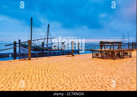 Europa, Portugal, Algarve, Litoral, Sotavento, Bezirk Faro, Olhao, Promenade an den Markthallen, historisches Fischerboot, Atlantiküberquerung 1808, Wahrzeichen, Caique Bom Sucesso, blaue Stunde Stockfoto