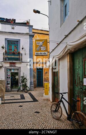 Europa, Portugal, Algarve, Litoral, Sotavento, District Faro, Olhao, Altstadtgasse mit Bar und Friseur, Hochformat Stockfoto