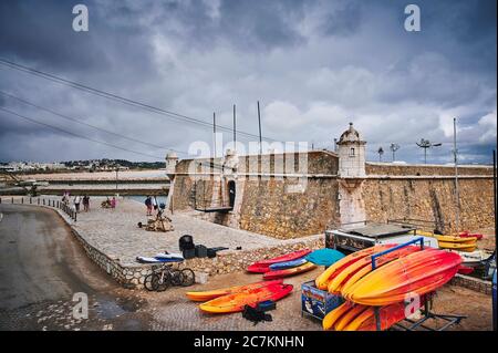 Europa, Portugal, Algarve, Litoral, Barlavento, Felsalgarve, Bezirk Faro, Lagos, Forte Ponta da Bandeira, mit bunten Kajaks im Vordergrund Stockfoto