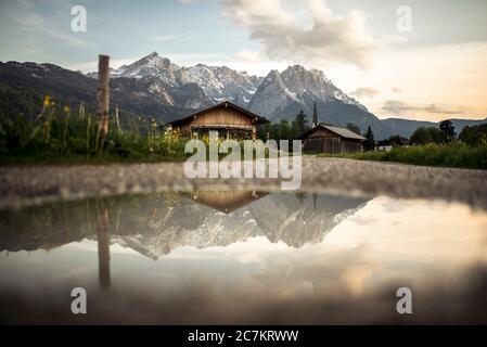 Zugspitzmassiv spiegelt sich in einer Pfütze wider Stockfoto