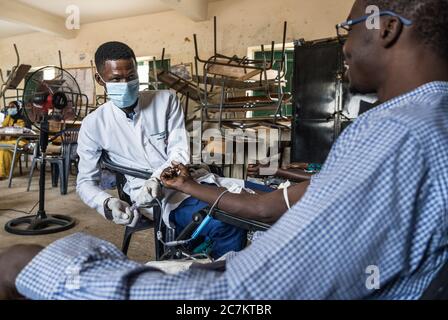 (200718) -- DAKAR, 18. Juli 2020 (Xinhua) -- EINE Krankenschwester nimmt Blut von einem Spender in Dakar, Senegal, 17. Juli 2020. Während das neue Coronavirus durch Senegal fegte, haben immer mehr Ärzte und Patienten im westafrikanischen Land einen der Schmerzen, die durch die Pandemie verschärft wurden, zu spüren bekommen - die Verknappung der Blutversorgung. Im Mai, zwei Monate nach der ersten Aufnahme, ist die Blutversorgung zu niedrig, sagte Saliou Diop, Direktor des Nationalen Zentrums für Bluttransfusion (CNTS). DAZU:'Feature: COVID-19 Pandemie verschlechtert die Blutversorgung in senegalesischen Krankenhäusern' (Foto: Louis D Stockfoto