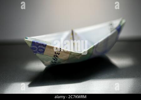 Papierboot mit Euro-Rechnungen gemacht. Allegorie über die Wirtschaft. Stockfoto